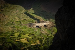 A glimpse across the Panj river into Afghanistan and the remnants of a natural snow cave villagers use as a natural refrigerator during the hot summer months.